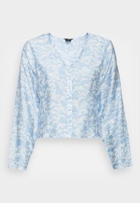 Blusa cropped azul clara com mangas longas, apresentando um padrão branco espiralado, um decote em V e um fecho frontal com botões. Textura suave.