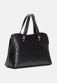 Borsa a tracolla in pelle nera con motivo impresso, due spallacci, hardware dorato e dettaglio con zip laterale su uno sfondo semplice.