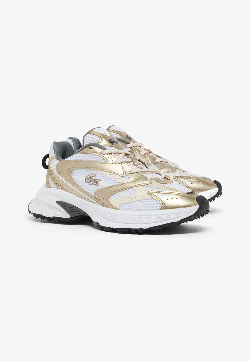 White athletic sneakers with gold accents, mesh and synthetic upper, textured sole, laces, and a black rubber tip at the front.