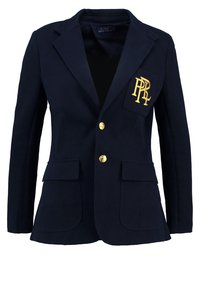 Blazer bleu marine avec boutons dorés et une poche poitrine avec un logo "PRL" brodé en or sur le côté gauche.