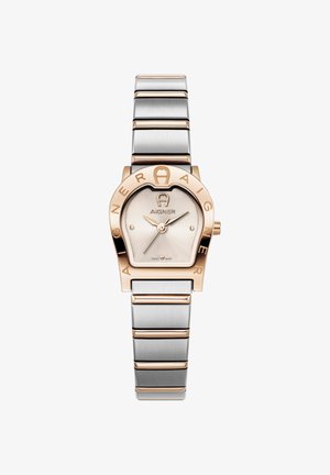 Rožu zelta un sudraba metāla pulkstenis ar apaļu korpusu, vienkāršu ciparnīcu un izteiktu "Aigner" logotipu ap malu. Aprīkots ar saites rokassprādzi.