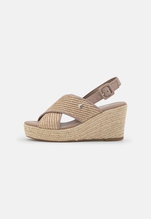 Wedge sandals with a beige woven upper and adjustable ankle strap, featuring a rope-wrapped platform and a textured sole.