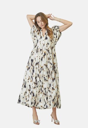 Vestido maxi en tejido ligero de varias capas con base blanca y patrones abstractos en negro y marrón, mangas cortas abullonadas y escote en V.