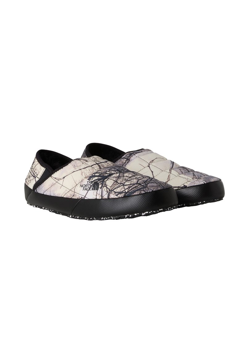 Vadderade slip-on-skor med ett mönster av vita och svarta grenarna och en svart gummisula samt mjuk svart foder.