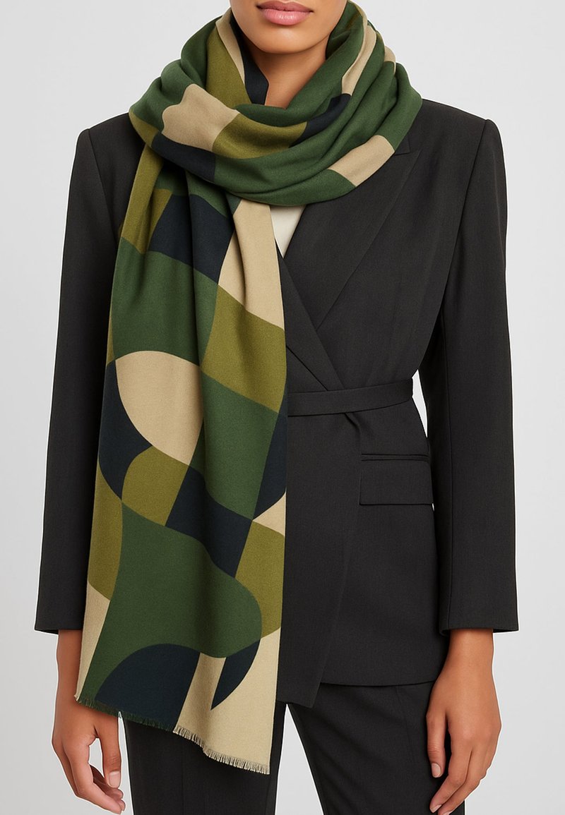 Sciarpa verde e beige con motivo, realizzata in tessuto morbido, con forme geometriche, bordi frangiati, appoggiata casualmente intorno al collo.