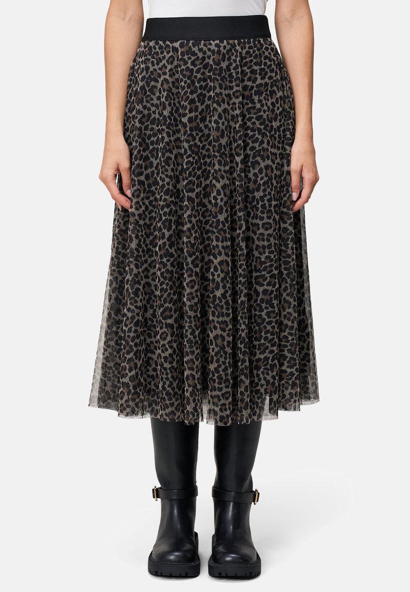 Plisseret midnederdel i gennemsigtigt sort stof med et leopardprintdesign, forsynet med en sort elastisk talje og båret med sorte knæhøje støvler.