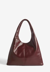Bordo kožna hobo torba s velikim, zakrivljenim otvorom i glatkom teksturom. Ima jednu debelu ručku i suptilan stikni detalj.