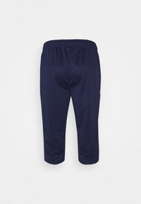 Tmavě modré sportovní kalhoty s volným střihem, elastickým pasem a zkrácenou délkou. Hladká textura, boční kapsy a žádné viditelné vzory.