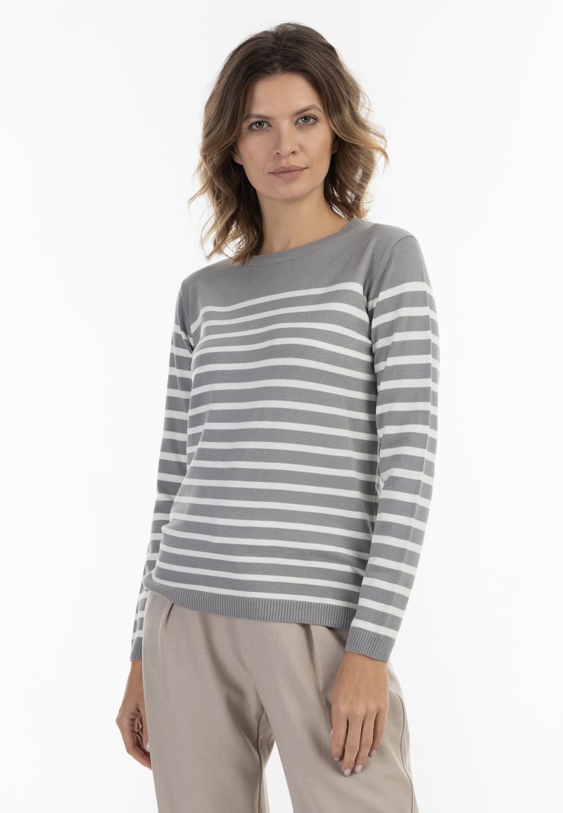 Maglione a righe grigie e bianche con scollo rotondo e maniche lunghe, realizzato in un materiale morbido e leggero. Abbinato a pantaloni beige.