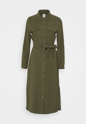 Sukienka koszulowa z długim rękawem w oliwkowym zielonym kolorze, z kołnierzykiem, zapinana na guziki z przodu, z dwoma kieszeniami na piersiach oraz z tkaninowym paskiem wiązanym w talii.