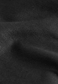 Tela negra con una textura suave y un patrón de tejido fino, que muestra ligeras variaciones en el tono y la profundidad de la superficie.
