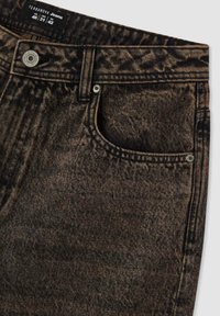 Czarne jeansy z denimu z teksturowanym, wyblakłym wzorem. Posiadają przednią kieszeń, srebrne okucia oraz metkę na pasku w talii.