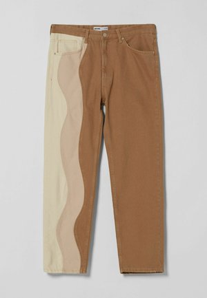 Zweifarbige Jeans mit braunem rechten Bein und cremefarbenem linken Bein mit wellenförmigem beigem Einsatz, mit Vordertaschen und Gürtelschlaufen.