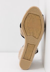 Sandale espadrille noire et beige avec une tige en tissu tissé, bride de cheville réglable et semelle en caoutchouc, taille indiquée 37, fabriquée en Espagne.