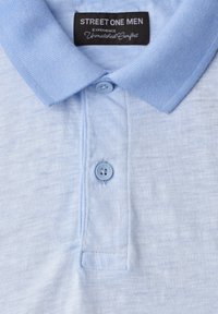 Polo bleu clair pour homme avec un col texturé doux, deux boutons et une étiquette noire indiquant "STREET ONE MEN."