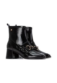 Botas de tobillo de charol negro con puntera afilada, tacón cuadrado, acentos de hardware en tono dorado y tiradores en la parte posterior para ponerlas y quitarlas con facilidad.