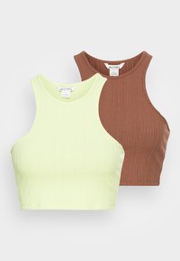 Dois tops cropped com nervuras: um em verde claro e outro em castanho. Ambos têm um decote redondo e são feitos de um tecido elástico.