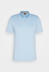 Polo bleu clair à manches courtes avec deux boutons, doubles rayures blanches sur les bords du col et petit logo sur le côté gauche de la poitrine.