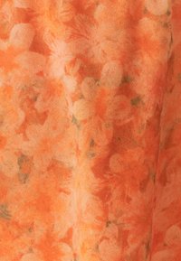 Tissu floral à texture douce dans des nuances d'orange, présentant un mélange de motifs floraux clairs et foncés.