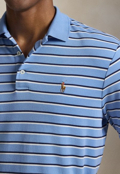 Ανοιχτό μπλε πόλο πουκάμισο με οριζόντιες ρίγες σε ναυτικό μπλε και λευκό, με μικρό κεντητό έμβλημα ιππέα στο στήθος.
