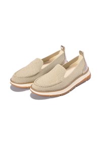 Beiga slip-on skor gjorda av texturerat tyg, med en mjuk ovandel, en vadderad innersula och en gummisula med en ljusbrun accent.