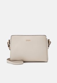 Bolso cruzado de cuero beige con una textura suave, forma rectangular, acentos de hardware dorado y una correa removible. Diseño y marca minimalistas.