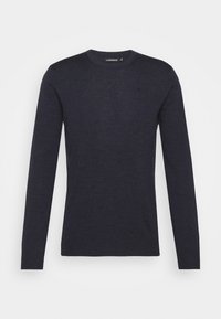 Mörk marinblå långärmad tröja med rund halsringning, ribbade muddar, minimal struktur och en liten logotyp på vänster bröst.