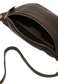 Ciemnobrązowa skórzana torba na ramię z częściowo otwartym srebrnym zamkiem, ukazującym czarną tkaninę wnętrza oraz regulowany pasek z dziurkami.