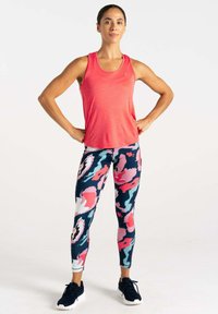 Rotes Sporttanktop kombiniert mit bunten, gemusterten Leggings in Marineblau, Pink und Weiß. Das Outfit besteht aus leichtem, dehnbarem Stoff.