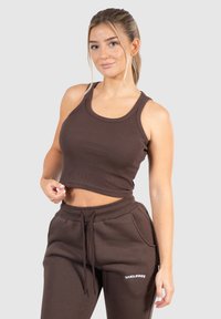 Brun ribbad kort topp i kombination med matchande joggers, med dragsko i midjan och logotypdetaljer, allt i ett mjukt, strukturerat tyg.