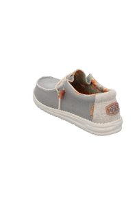 Zapato gris de tipo slip-on con tela texturizada, acentos en beige claro que contrastan, costuras decorativas y una etiqueta con el logo en el talón. Suela ligera.