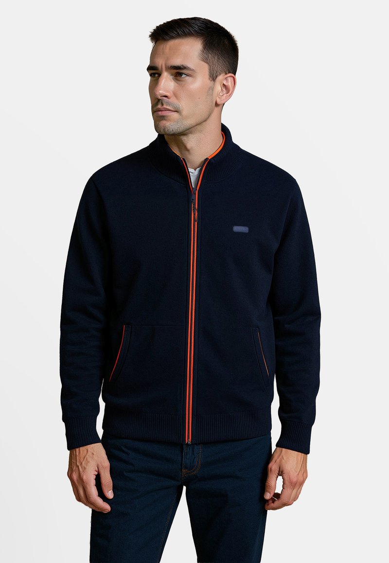 Marine blauwe rits-sweater met een oranje accento rits en geribde manchetten, voorzien van zijzakken en een vlakke gebreide kraag voor extra comfort.