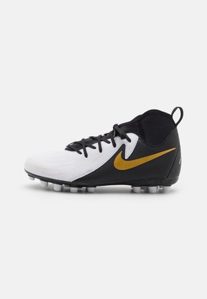 Crampons de soccer noir et blanc avec une tige texturée, présentant un logo Nike doré bien visible et des lacets ajustables, conçus pour l'adhérence.