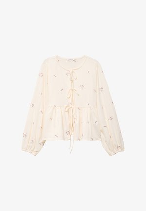 Blusa color crema con mangas largas, cierre frontal con lazo y bordado floral en tonos rosas. Presenta un diseño fruncido y fluido.