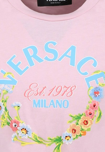 Różowa bawełniana koszulka z niebieskim napisem "VERSACE", "Est. 1978" w kolorze różowym oraz wzorem kwiatowego wieńca w żywych kolorach.