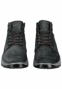 Botas de tobillo de cuero gris oscuro con superficie texturizada, punta redonda, cordones marrones y suela de goma con un patrón de agarre.