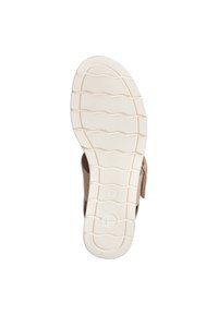 Sandale beige vue du dessous, présentant une semelle extérieure en caoutchouc blanc texturé avec des motifs de semelle ondulés et une étiquette de taille marquée '37'.