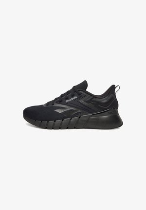 Zapatilla deportiva negra Reebok con parte superior de malla, suela acolchada, cierre de cordones y logotipo de la marca en el lateral y en la lengüeta del talón.