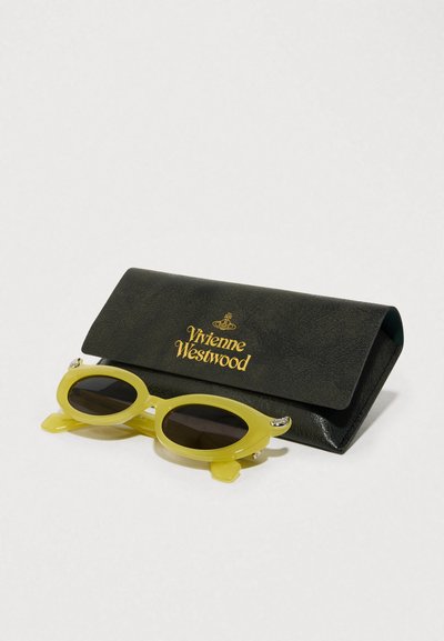 Κίτρινες πλαστικές γυαλιά ηλίου με σκούρους φακούς, συνοδευόμενα από μία σκούρα πράσινη υφασμάτινη θήκη με χρυσή σήμανση "Vivienne Westwood".