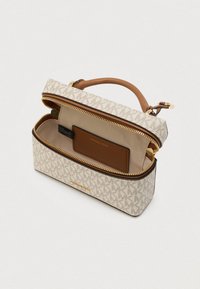 Getextureerde beige tas met gouden ritssluiting, voorzien van een monogrampatroon. Bruine lederen accenten en een binnenvak voor kaarten verbeteren de functionaliteit.