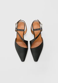 Čierne slingback podpätky s špicatou špičkou, so tkaným textúrou na prednej časti a hladkými koženými akcentmi. Hnedé vnútorné stélky s logom.