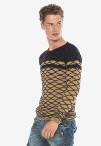 Strickpullover mit geometrischem Muster in wechselnden Schwarz- und Beigetönen. Rundhalsausschnitt, figurbetonte Passform, gerippte Bündchen und Saumdetails.
