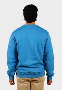 Modrá mikina s okrúhlym výstrihom a rebrovanými manžetami a pásom, vyrobená z hladkej látky, zobrazená zozadu na neutrálnej pozadí.