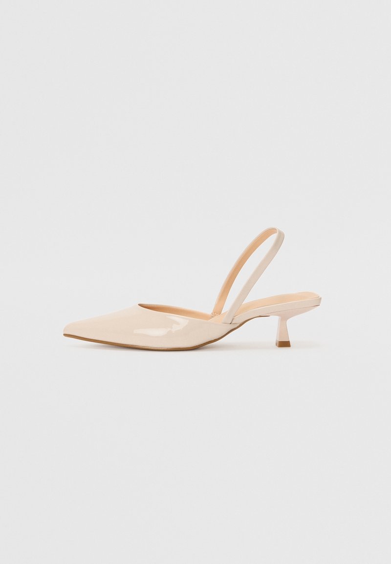 Chaussures slingback en cuir verni beige avec un bout pointu, un petit talon carré et une bride minimaliste, présentant une finition lisse et brillante.