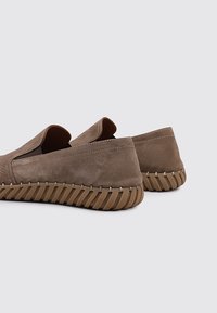 Zapatos marrones tipo mocasín hechos de ante texturizado con suela de goma. Presentan costuras contrastantes y un respaldo acolchado para mayor comodidad.