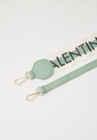 Due fasce con hardware dorato; una è in pelle verde menta, l'altra presenta una fascia crema con "VALENTINO" in grassetto testo nero.