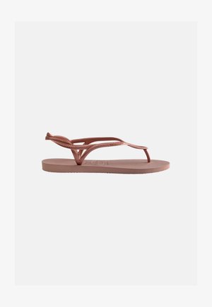 Single pink rubber flip-flop sandal with textured sole and braided strap detail against a plain light background.
