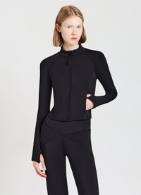 Giacca sportiva nera con colletto alto, maniche lunghe e chiusura con zip, abbinata a pantaloni aderenti coordinati con dettagli delle cuciture.