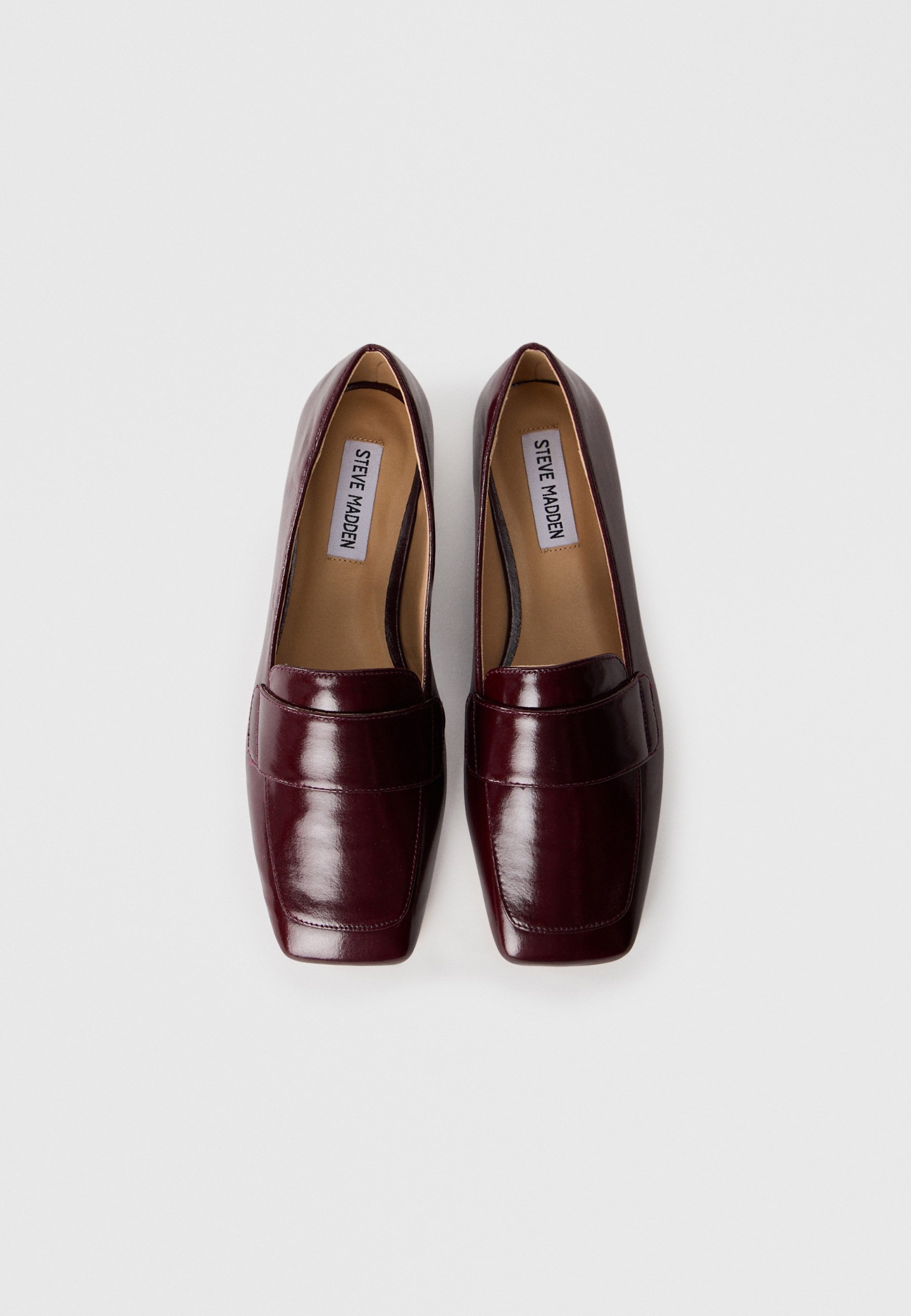 Burgundske usnjene mokasine s kvadratnim nosom, ki imajo izrazit šivani pas po vampu in gladko, sijajno površino.