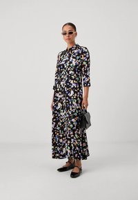 Μάξι φόρεμα με floral μοτίβα σε μαύρη βάση με πολύχρωμα σχέδια, μανίκια τριών τετάρτω�ν και κουμπιά στο μπροστινό μέρος. Φορεμένο με μαύρες μπαλαρίνες.